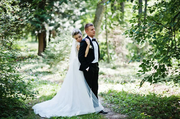 Stylish and gorgeous wedding couple walking outdoor at park on s — Stock Photo, Image