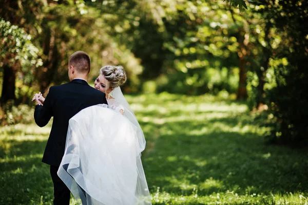 Stylish and gorgeous wedding couple walking outdoor at park on s — Stock Photo, Image