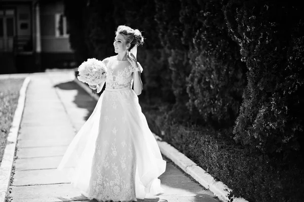 Geweldig prachtige blonde bruid met bruiloft boeket op handen op s — Stockfoto