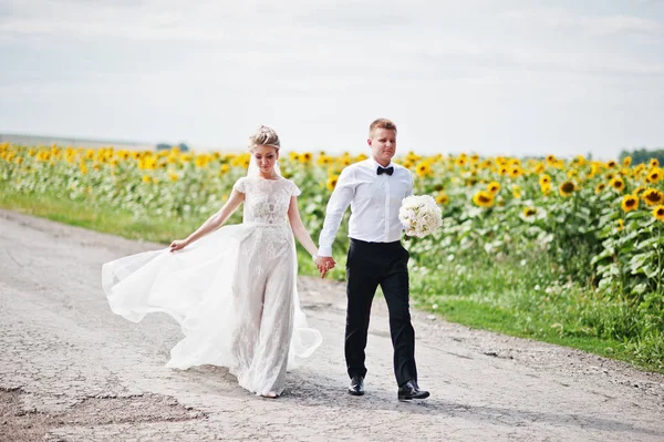 Bröllopsparet på solrosor fält i kärlek. — Stockfoto