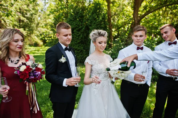 Elegancia boda pareja con damas de honor y mejores hombres beber — Foto de Stock
