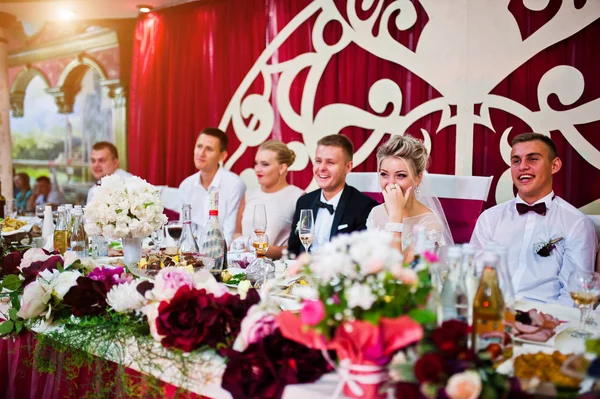 Casamento casal sentado na mesa no restaurante com seus amigos — Fotografia de Stock