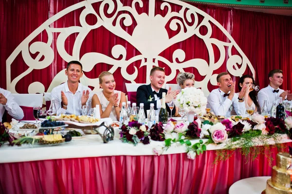 結婚式のカップルが彼らの友人とレストランでテーブルに座っています。 — ストック写真
