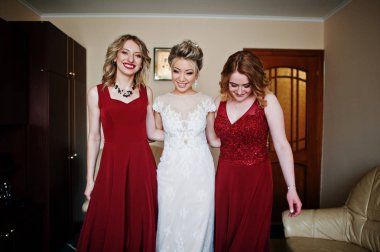 Nedime ile sarışın gelin odasında morni üzerinde kırmızı elbise giymek