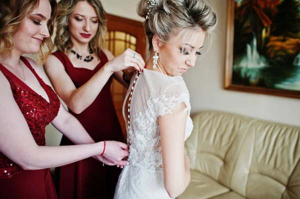 Damas de honor ayudaron a usar vestido de novia en la mañana de la boda . — Foto de Stock