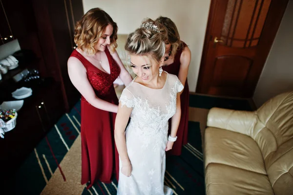 Damas de honor ayudaron a usar vestido de novia en la mañana de la boda . —  Fotos de Stock