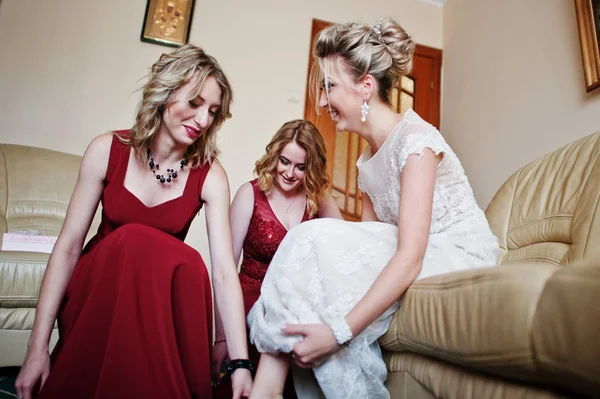 Damas de honor ayudaron a usar zapatos novia en la mañana de la boda . — Foto de Stock