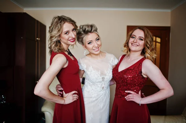 Mariée blonde avec demoiselles d'honneur porter sur la robe rouge à la chambre sur morni — Photo