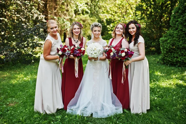 Hermosa novia rubia con cuatro damas de honor en rojo y beige dre — Foto de Stock