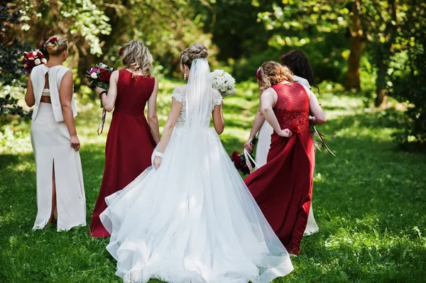 Splendida sposa bionda con quattro damigelle d'onore in rosso e beige dre — Foto Stock