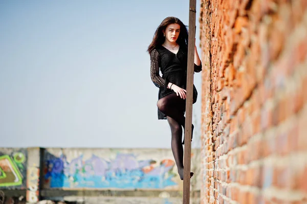 Retrato menina morena com lábios vermelhos usando um vestido preto posou — Fotografia de Stock