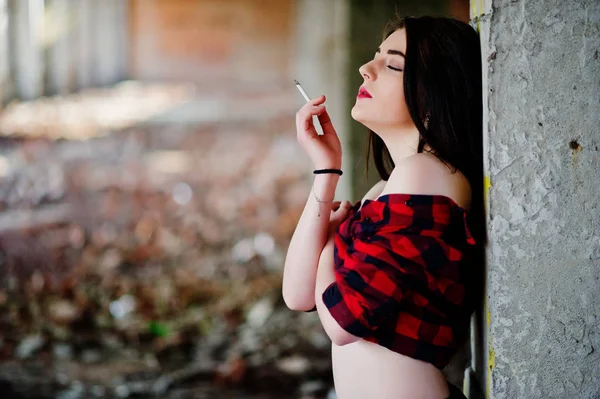 Chica fumadora de retratos con labios rojos usando un shir a cuadros rojo — Foto de Stock