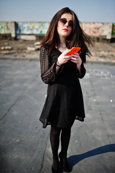 Retrato chica morena con labios rojos y teléfono móvil naranja en — Foto de Stock