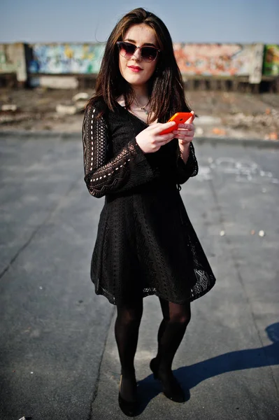 Retrato chica morena con labios rojos y teléfono móvil naranja en — Foto de Stock