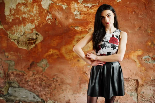 Goth flicka på svart läder kjol ställde mot grunge vägg — Stockfoto