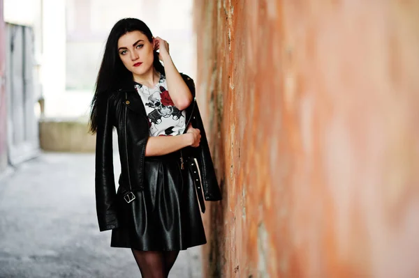 Joven chica gótica en falda de cuero negro y chaqueta contra grunge — Foto de Stock