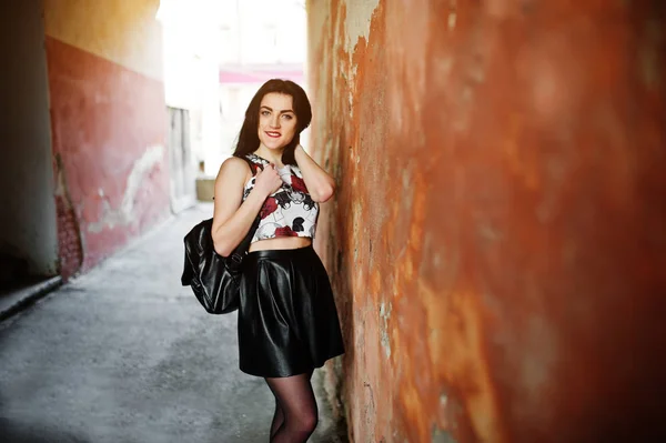 Joven chica gótica en falda de cuero negro con mochila posado de nuevo —  Fotos de Stock
