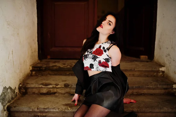 Joven chica gótica en falda de cuero negro y chaqueta posada en la escalera —  Fotos de Stock