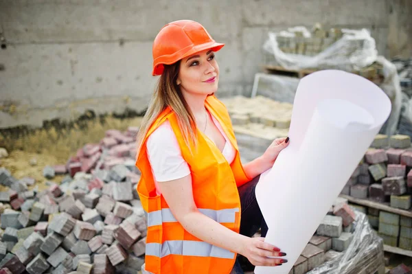Engineer builder woman in uniform waistcoat and orange protectiv