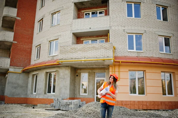 Engineer builder woman in uniform waistcoat and orange protectiv