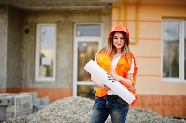 Engineer builder woman in uniform waistcoat and orange protectiv