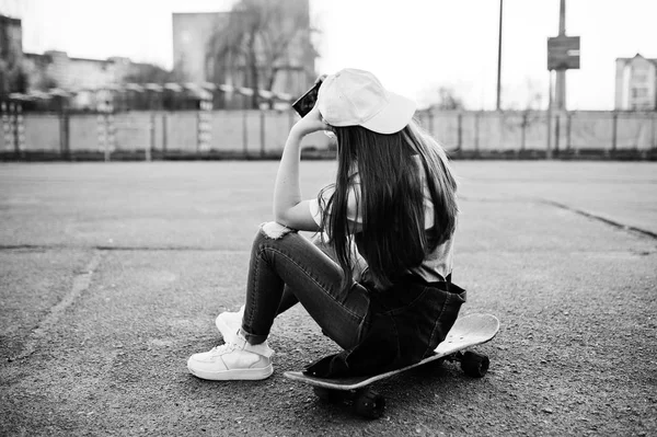Jeune adolescente urbaine avec skateboard, porter des lunettes, casquette a — Photo