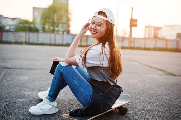 Jovem adolescente urbana com skate, desgaste em óculos, cap a — Fotografia de Stock