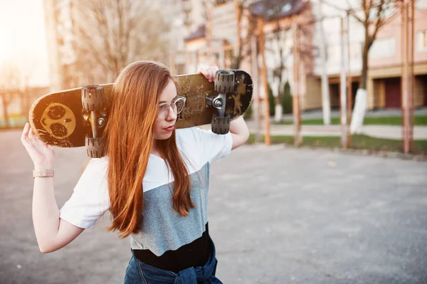 Young teenage urban girl with skateboard, wear on glasses, cap a — Stock Photo, Image