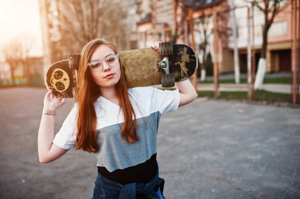 Young teenage urban girl with skateboard, wear on glasses, cap a — Stock Photo, Image