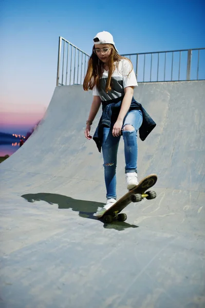 Молодая городская девушка-подросток со скейтбордом, носить очки, кепка — стоковое фото