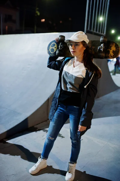 Молодая городская девушка-подросток со скейтбордом, носить очки, кепка — стоковое фото