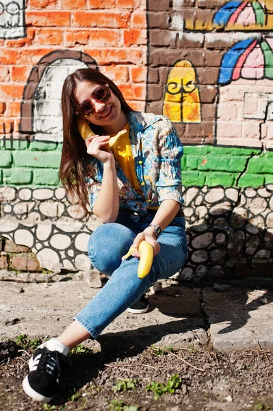 Hermosa chica adolescente divertida hablando plátanos como el teléfono, usar yel — Foto de Stock