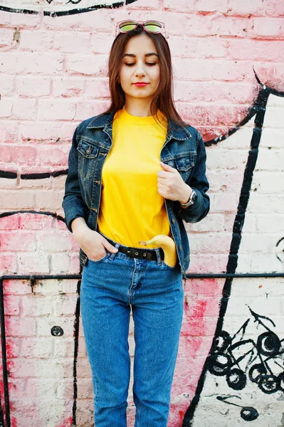 Vacker tonårsflicka bära gul t-shirt och jeans nära graffi — Stockfoto
