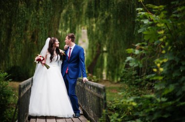 Güneşli gün park küçük köprüde Düğün çifti aşık et