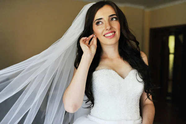 Bela noiva morena sorridente no vestido de noiva perto da janela no — Fotografia de Stock