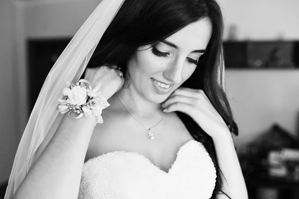 Улыбающаяся невеста-брюнетка в свадебном платье у окна — стоковое фото