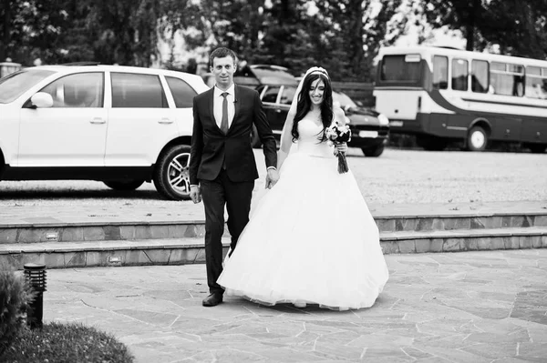 Casamento casal se mudando para o restaurante contra carros cortege . — Fotografia de Stock