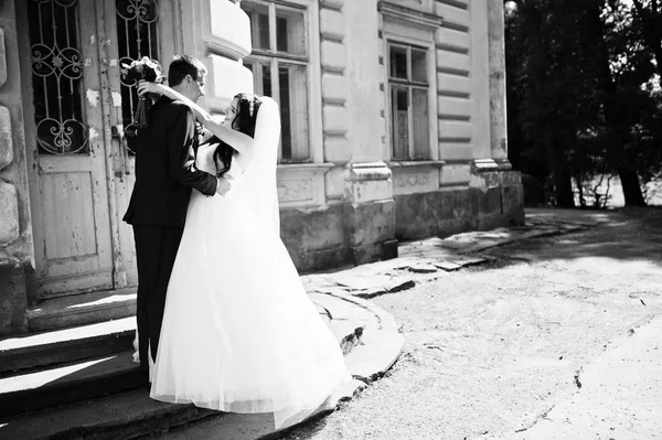 Verliebtes Hochzeitspaar bleibt gegen alten Vintage-Palast. — Stockfoto