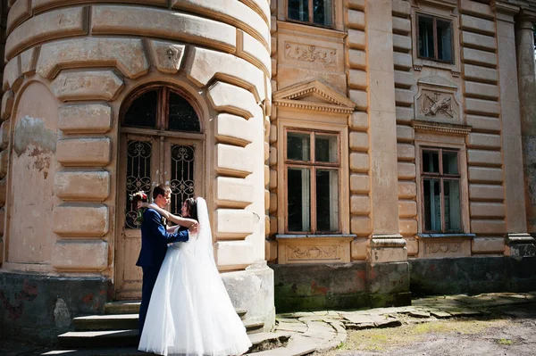 Verliebtes Hochzeitspaar bleibt gegen alten Vintage-Palast. — Stockfoto