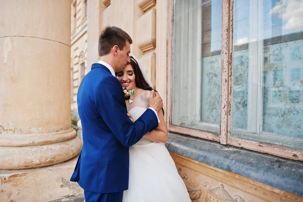 Verliebtes Hochzeitspaar bleibt gegen alten Vintage-Palast. — Stockfoto