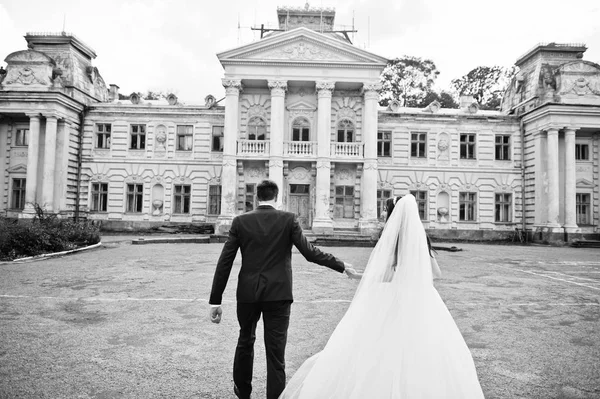 Verliebtes Hochzeitspaar bleibt gegen alten Vintage-Palast. — Stockfoto