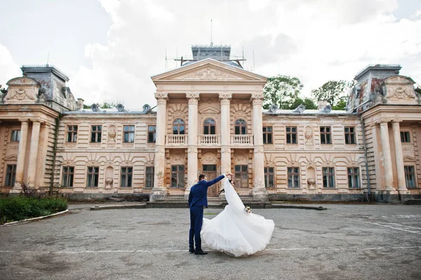 Verliebtes Hochzeitspaar bleibt gegen alten Vintage-Palast. — Stockfoto