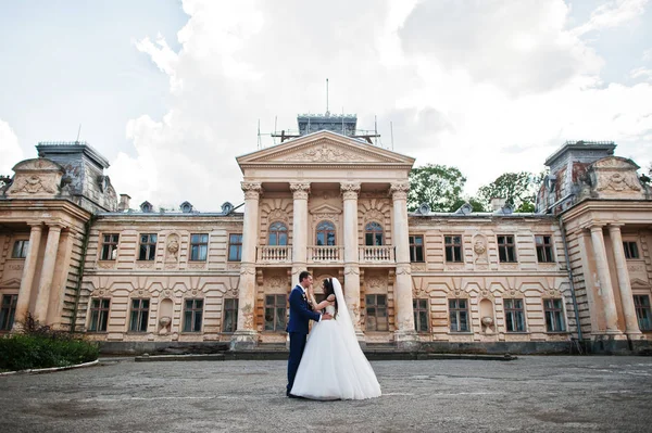 Verliebtes Hochzeitspaar bleibt gegen alten Vintage-Palast. — Stockfoto