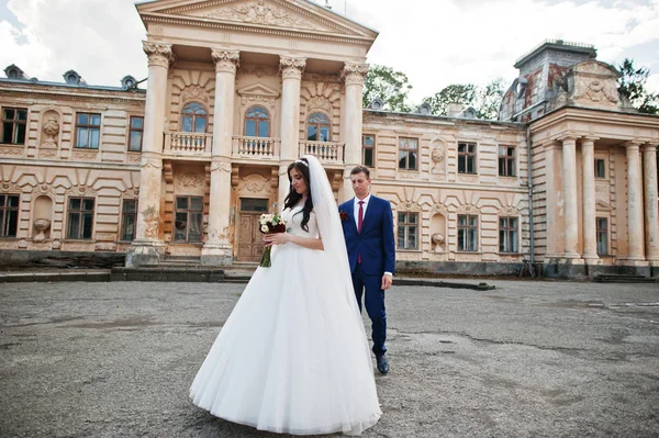 Verliebtes Hochzeitspaar bleibt gegen alten Vintage-Palast. — Stockfoto