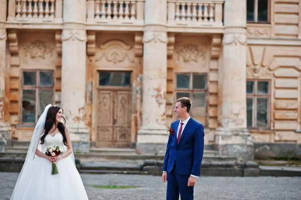 Casamento casal apaixonado ficar contra o velho palácio vintage . — Fotografia de Stock