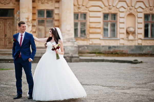 Casamento casal apaixonado ficar contra o velho palácio vintage . — Fotografia de Stock