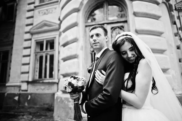 Verliebtes Hochzeitspaar bleibt gegen alten Vintage-Palast. — Stockfoto