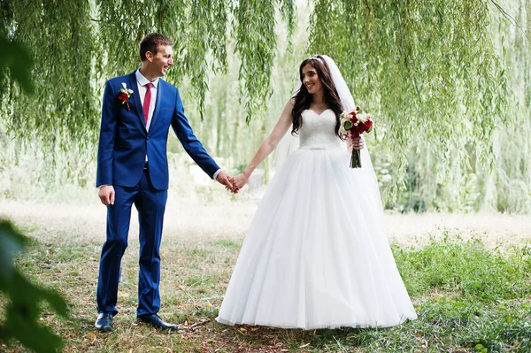 Casamento casal apaixonado abraçando no parque no dia ensolarado . — Fotografia de Stock