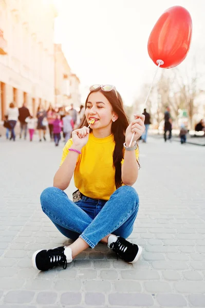 Ung tonårsflicka som sitter på gatorna i staden med lollipop och — Stockfoto