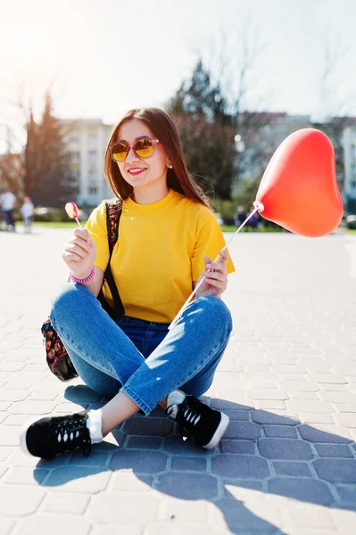 Ung tonårsflicka som sitter på gatorna i staden med lollipop och — Stockfoto